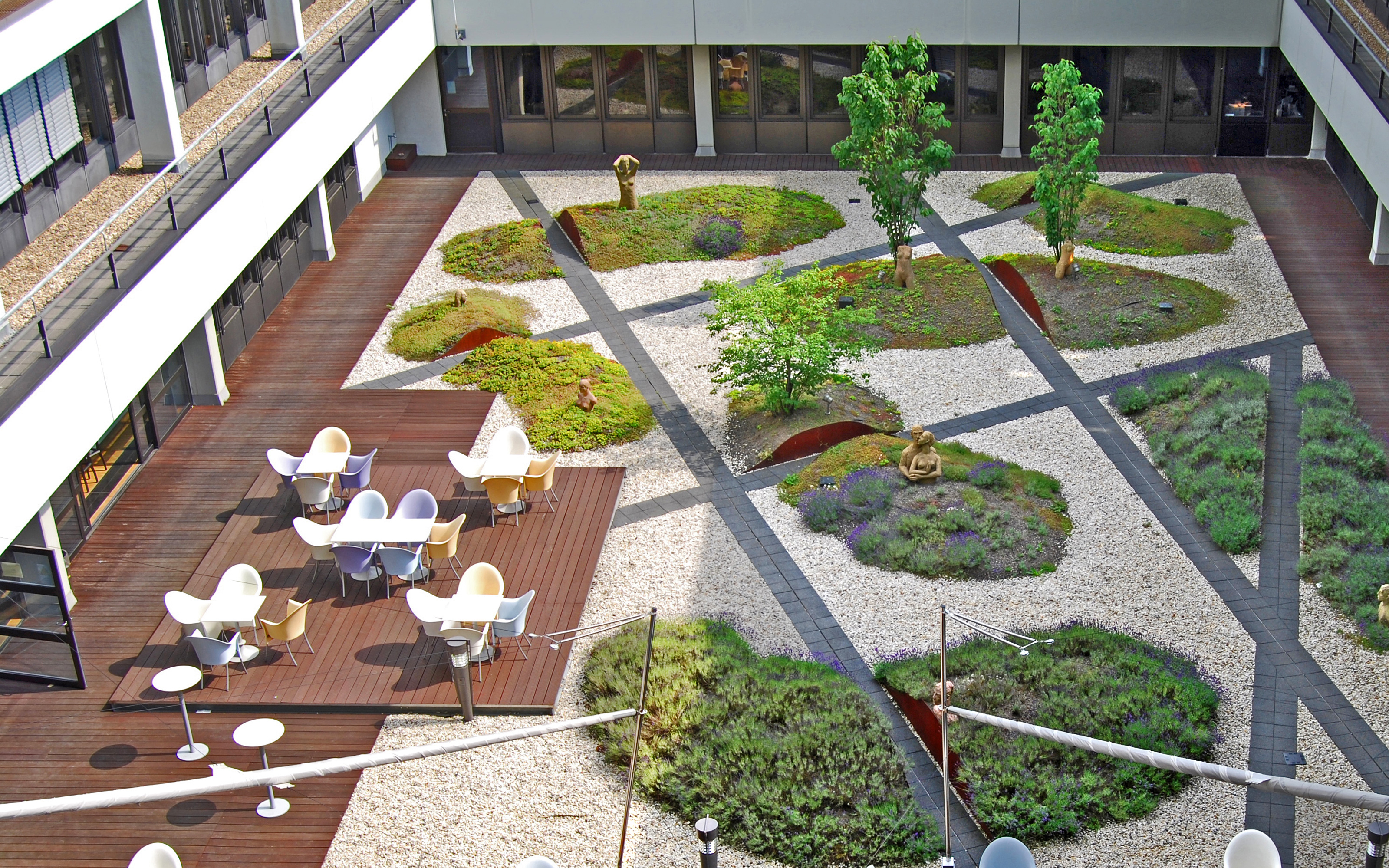 Courtyard with wooden deck, seating, gravel and plantbeds