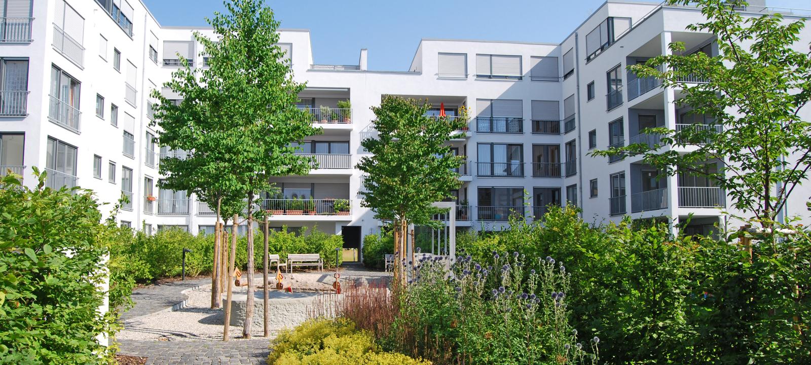 Green courtyard with shrubs, trees and playground