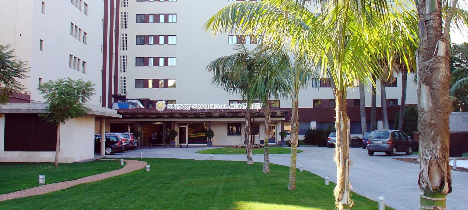 Lawn and palm trees infront of a hotel