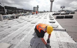 Installer applying drainage sheets Fixodrain® XD 20 on a roof