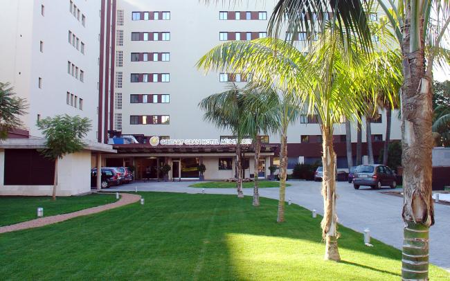 Lawn and palm trees infront of a hotel